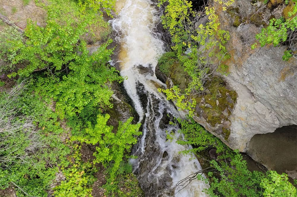 A top-down perspective of Powers Creek cutting through rugged terrain and spring greenery along the Glen Canyon Greenway trail.